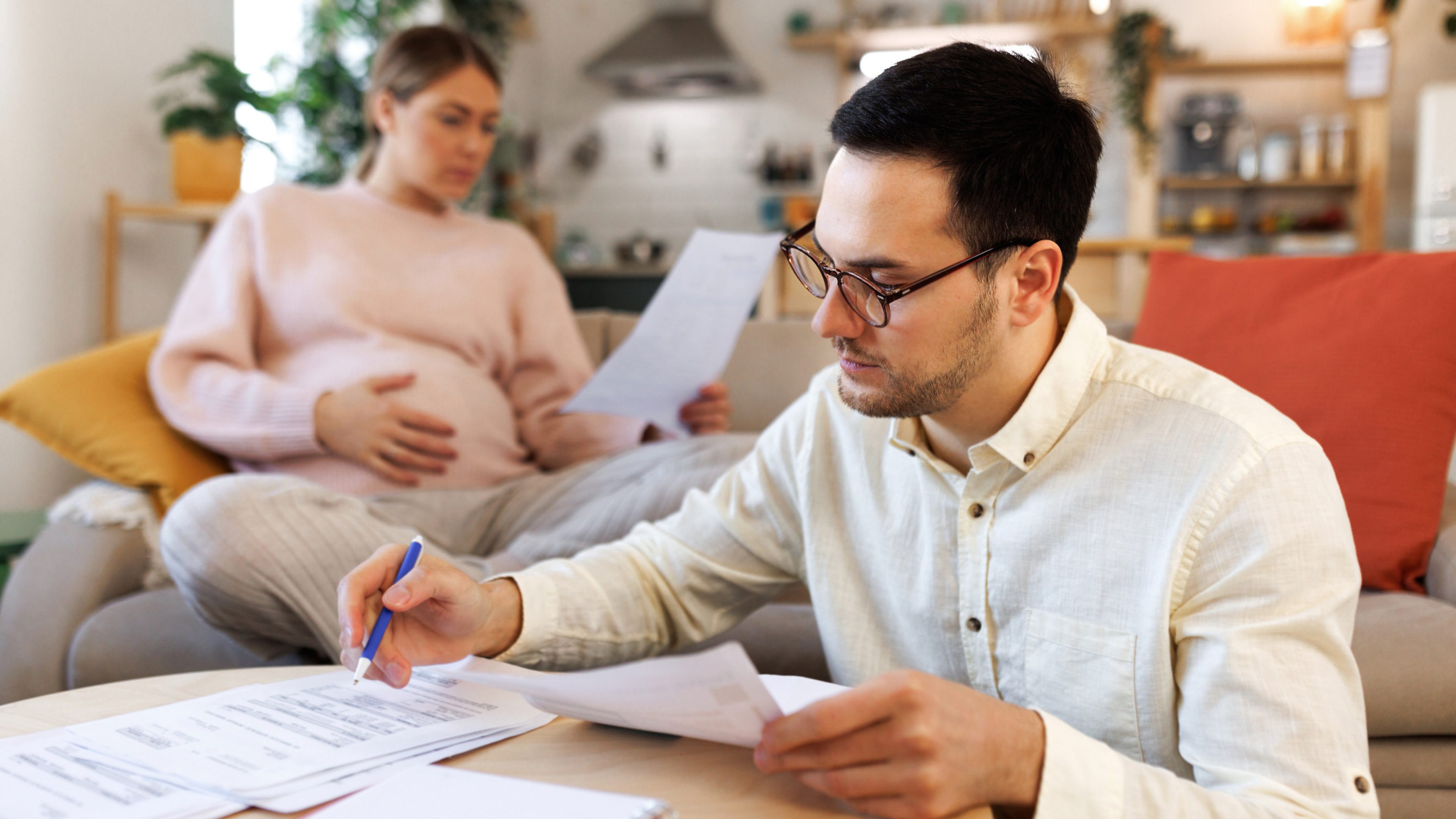 Couple sitting in their living room and checking their finances