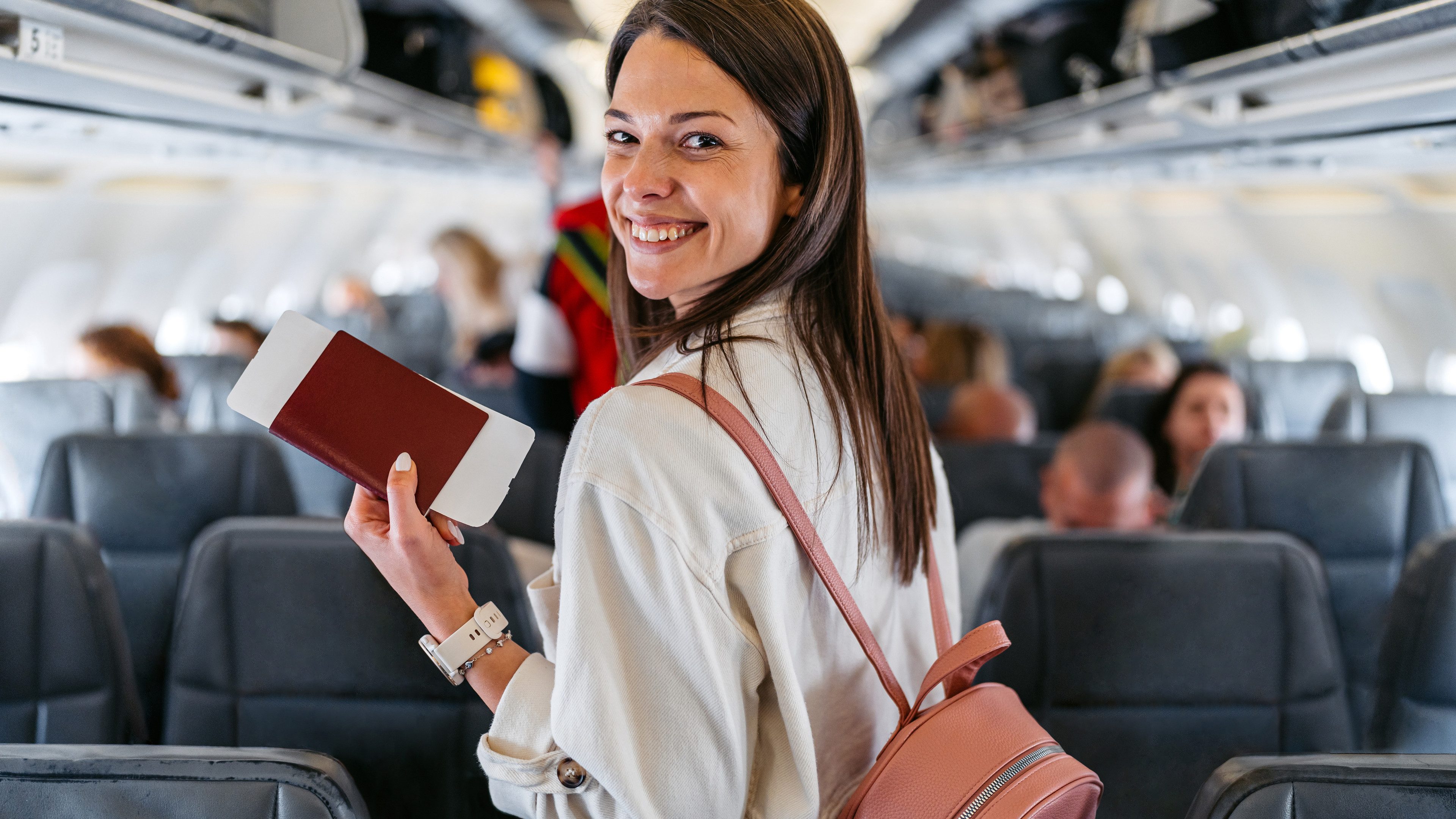 Portrait of a beautiful young woman boarding an airplane in Austria. Finding her seat.